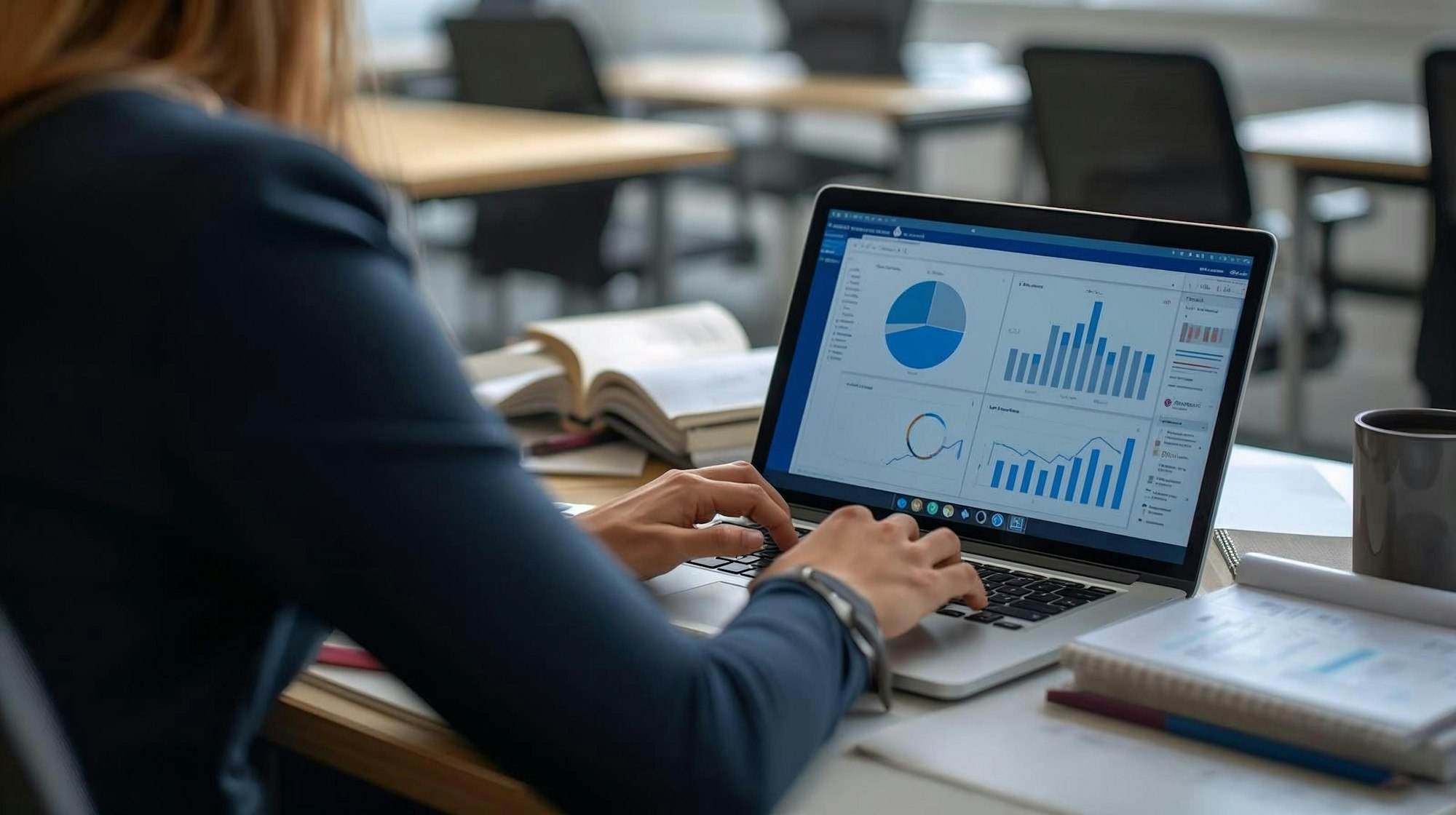Dizüstü bilgisayarda grafik ve tablolarla veri analizi yapan bir kişi