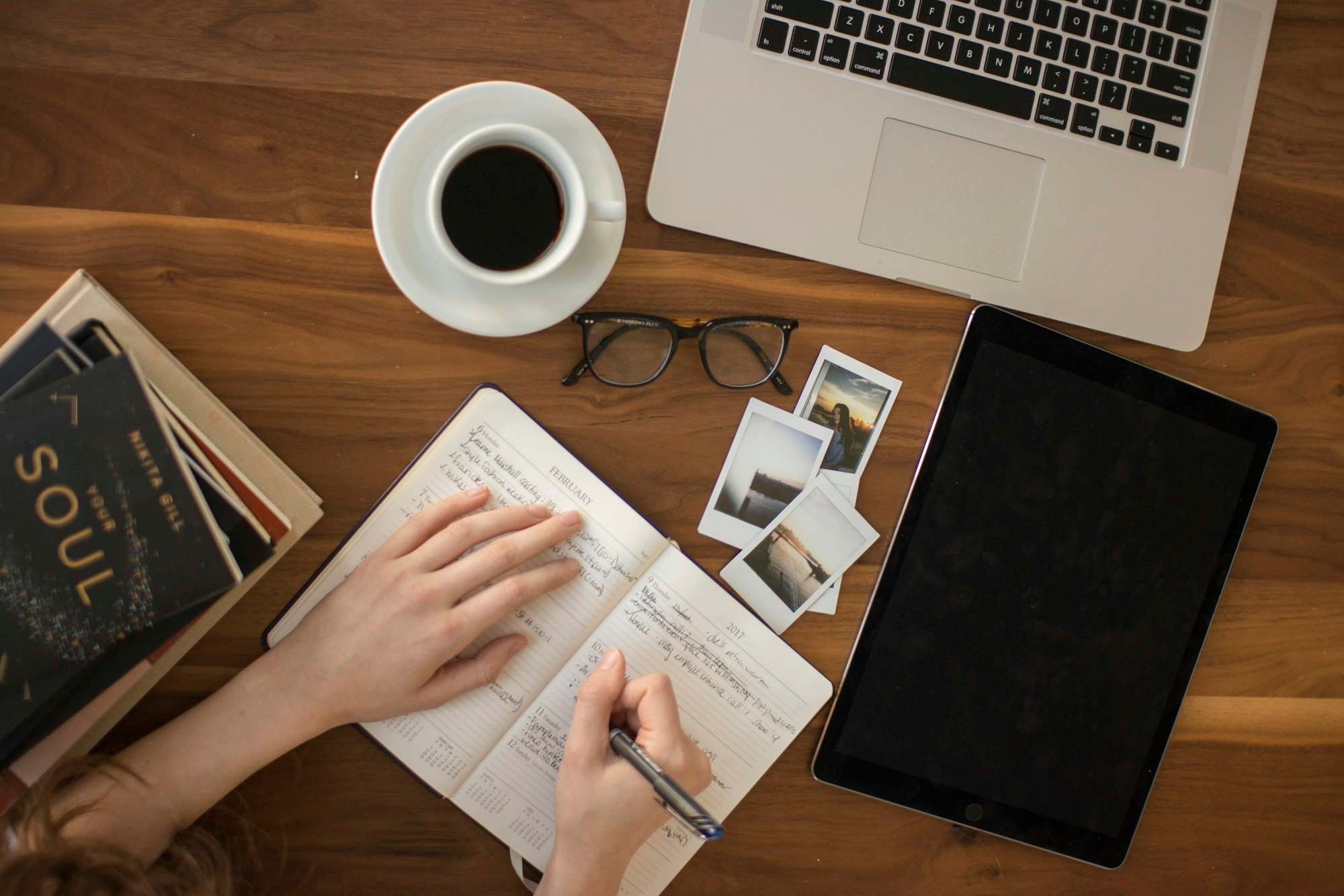 Defter, kahve ve dizüstü bilgisayarın bulunduğu çalışma masası